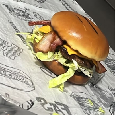 Pão de brioche, hambúrguer de 80g, alface americana, maionese, queijo cheddar e bacon.