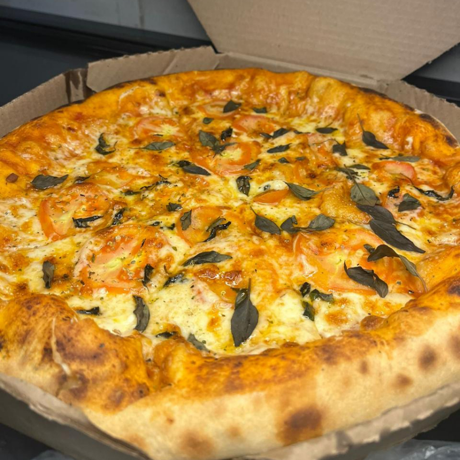 Massa com fermentação natural e artesanal, molho de tomate especial caseiro, queijo mussarela, tomate em fatias e folhas de manjericão.