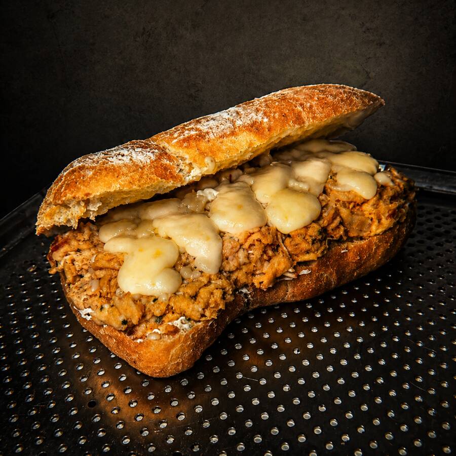Lanche artesanal feito com: Pão ciabatta artesanal, crocante por fora e macio por dentro, recheado com frango desfiado cremoso e bem temperado, com queijo e rúcula fresca. Combinação marcante, com sabor intenso e equilibrado.