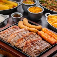 Bife Chorizo Angus 800g in natura. Acompanha: Arroz branco, feijão tropeiro, batata frita, banana à milanesa, queijo coalho, paçoca de carne, mandioca cozida, vinagrete e chimichurri.