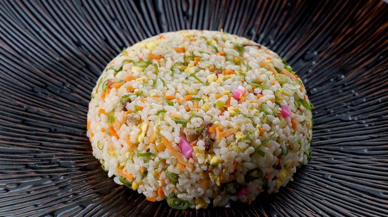 Arroz japonês com legumes, porco e ovo salteado na frigideira