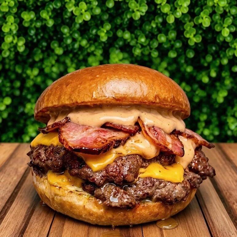 "A combinação perfeita de técnica e sabor! Dois suculentos discos de carne de 75g cada, prensados na chapa bem quente para criar aquela crostinha caramelizada que todo mundo ama. Cobertos com duas fatias de queijo cheddar derretido, fatias crocantes de bacon premium e finalizado com nosso pão super macio. É a explosão de sabor que o seu dia merece!"
Obs: o molho escolhido vai dentro do Burger