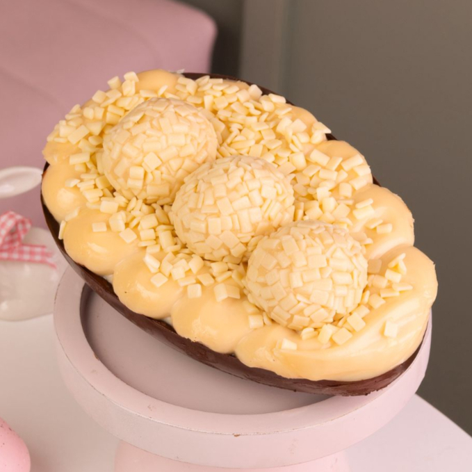 Ovo de Páscoa feito com casca de chocolate nobre ao leite, recheada com brigadeiro de Ninho e uma camada de Nutella Original. Finalização com 3 brigadeiros e acompanha uma sacola de presente Dandoce. 500G
